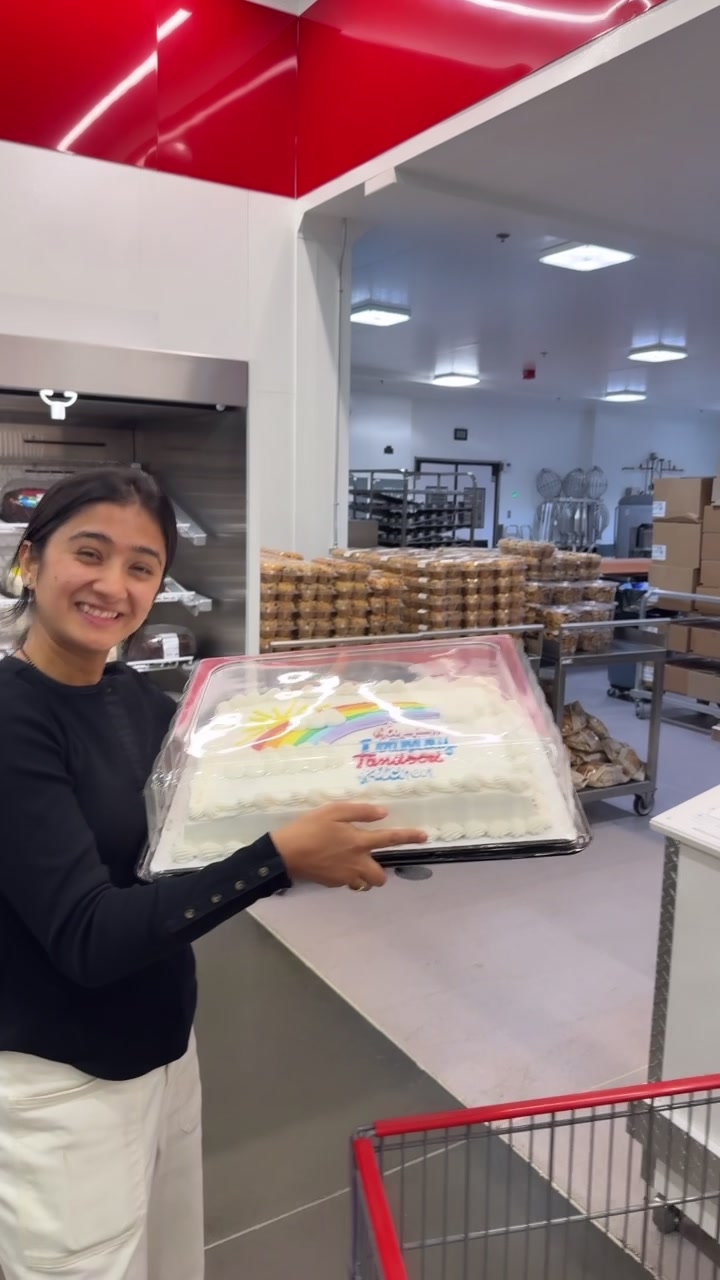 A Tandoori Kitchen team member holds the anniversary cake.
